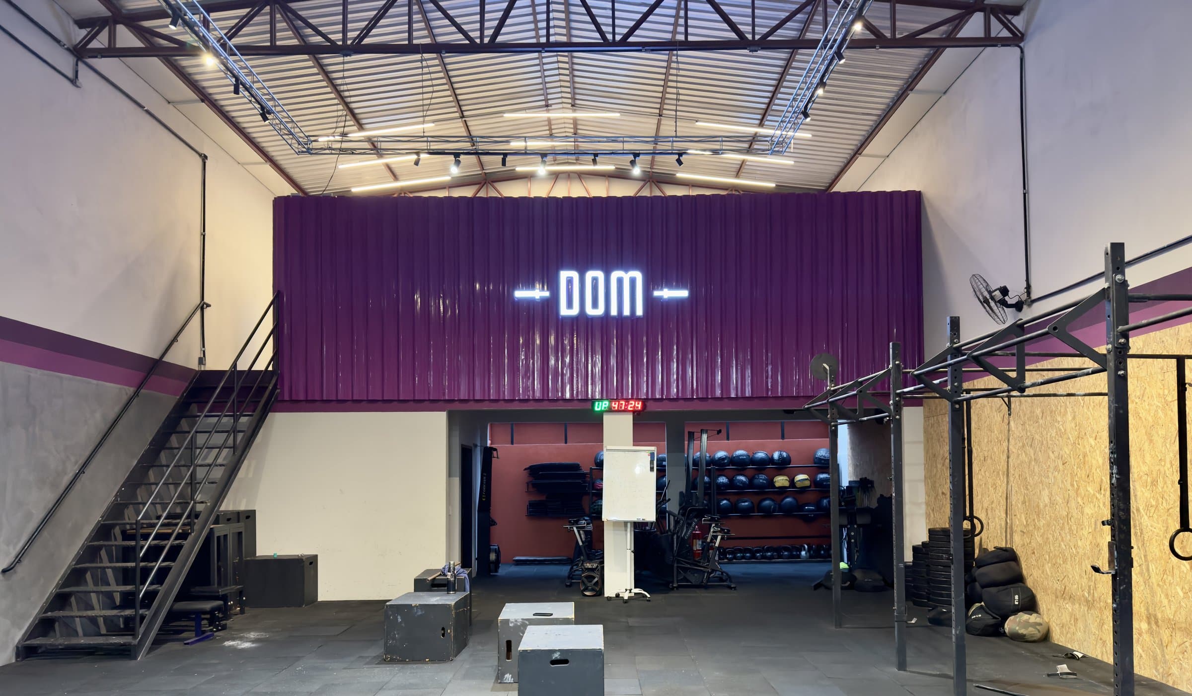 Interior do box DOM CF, com o letreiro DOM na parede roxa